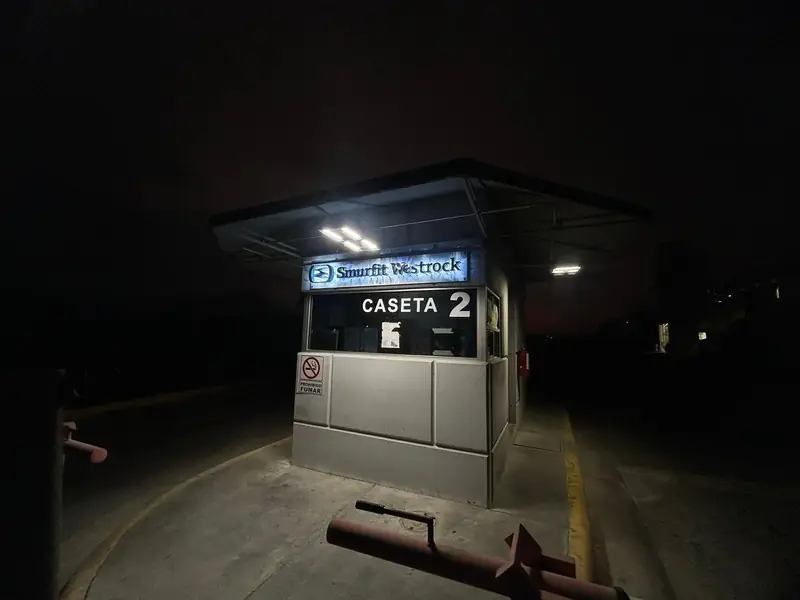 Anuncio luminoso de Smurfit Westrock sobre la caseta de acceso de la planta, de noche